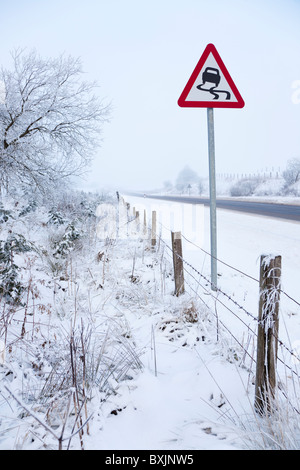 Chemin d'hiver avec le gel brouillard, neige et avertissement près de Floak sur la route entre Kilmarnock et Glasgow, Ecosse Banque D'Images