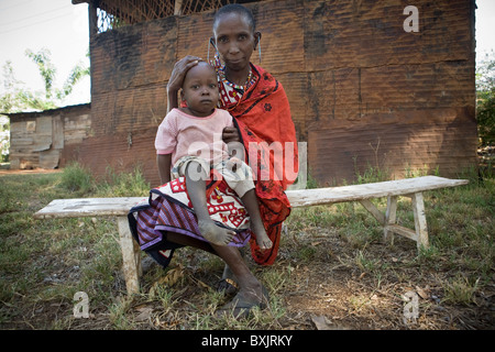 Portrait d'un Masaï avec son petit-fils qui souffre avec un pied bot - Tanzanie, Afrique de l'Est. Banque D'Images