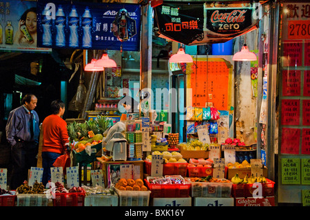 Les clients d'Orient en face du marché de fruits et légumes au centre-ville de Hong Kong, Chine Banque D'Images