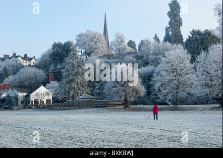 Femme promener son chien par la rivière en hiver à Ross-on-Wye Banque D'Images