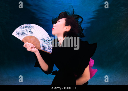 Femme en kimono tenant un sous-marin du ventilateur Banque D'Images