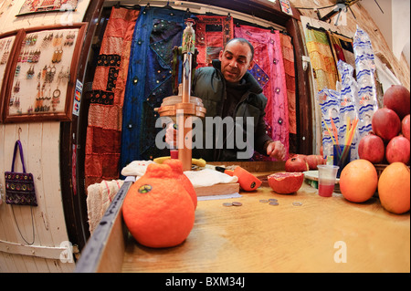 Israël, Akko. Vendeur de jus pressant des oranges dans le marché arabe de la vieille ville d'Akko. Banque D'Images