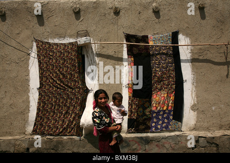 Jeune fille avec un enfant dans le village tsigane de Gigikhana près de Boukhara, Ouzbékistan. Banque D'Images