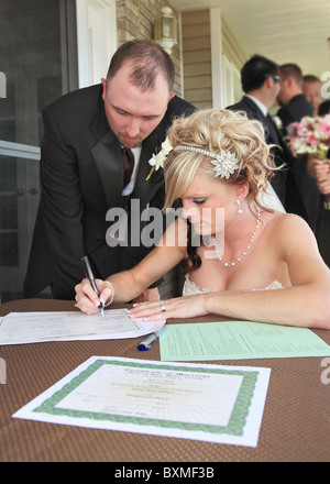 Jeune beau couple signature des certificats de mariage Banque D'Images