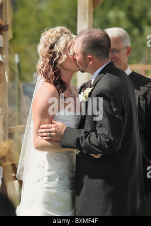 Cérémonie de mariage de jeunes mariés premier baiser Banque D'Images