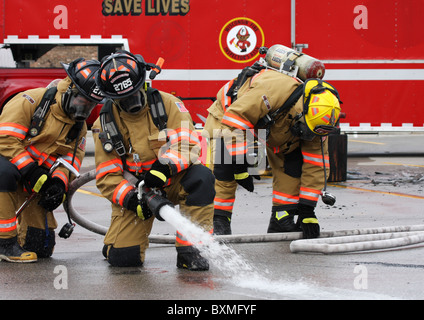 Les pompiers sur un hoseline la lutte contre l'incendie pour sauver des vies Banque D'Images