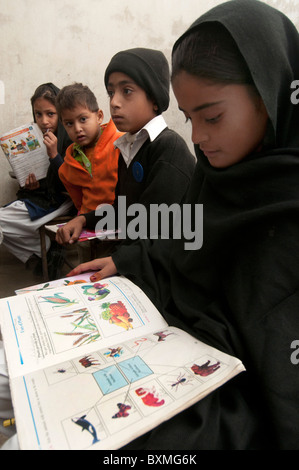 Le Pakistan après le déluge.Al Haq école publique. Risal zone pur. 230 élèves, 9 enseignants.Les élèves de lire les manuels donnés Banque D'Images