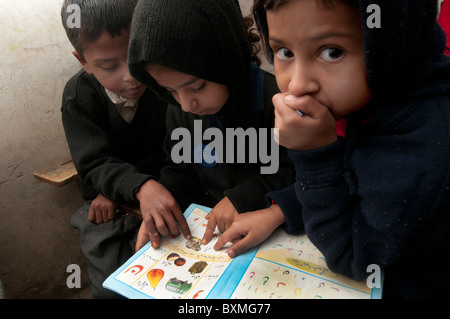 Le Pakistan après l'inondation, Al Haq école publique. Risal zone pur. 230 élèves, 9 enseignants.Les élèves de lire les manuels donnés Banque D'Images