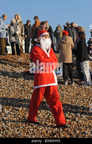 Des centaines de personnes se rassemblent sur la plage de Brighton à surveiller et prendre part à la Journée annuelle de Noël nager Banque D'Images