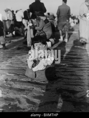 Un petit enfant coréen cherche sa famille comme la Les réfugiés fuient à travers le fleuve Taedong un Pyongyang, Corée du Nord Banque D'Images