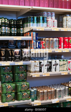 Des bouteilles en verre et de l'aluminium des canettes de bière sur les étagères des magasins Banque D'Images