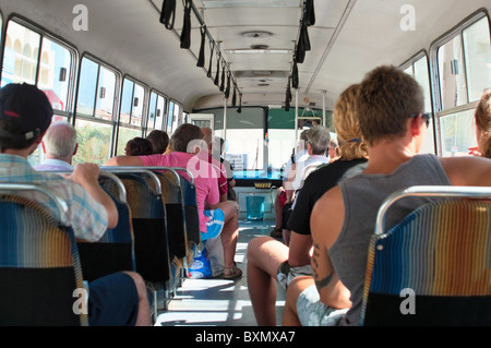 Plusieurs touristes un des passagers assis dans la navette des entraîneurs. La vue depuis l'arrière. Chypre, Europe Banque D'Images