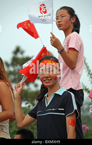 Des jeunes filles chinoises branle des drapeaux nationaux lors de la Parade des Jeux pré-olympiques, à Beijing, en Chine Banque D'Images