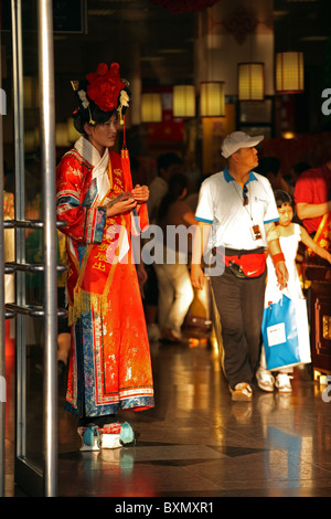 Femme en costume national debout à la porte du magasin à Pékin, Chine Banque D'Images
