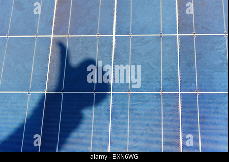 Close up de panneau solaire avec Thumbs up shadow Banque D'Images