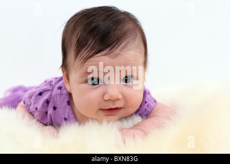 Infant baby girl in studio portant sur l'estomac, bénéficiant à plat ventre Banque D'Images