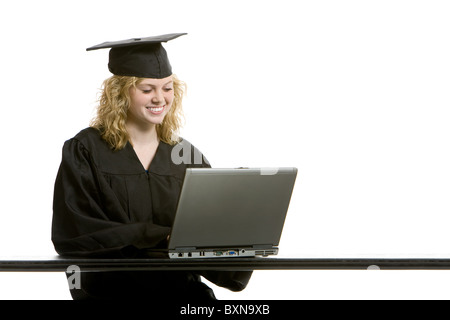 Jeune fille de diplôme sur ordinateur avec fond blanc Banque D'Images