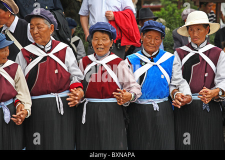 Les femmes Naxi dancing in street, Lijiang, Yunnan Province, China Banque D'Images