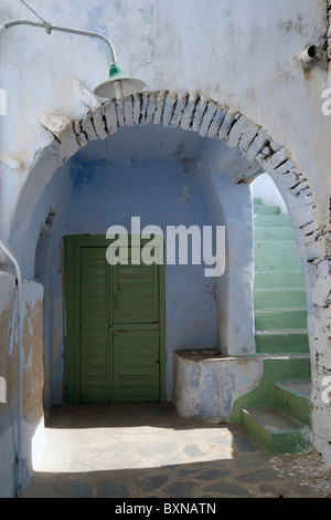 Archway menant à l'escalier d'une ruelle typique dans un petit village de l'île de Tinos Cyclades grecques. Banque D'Images