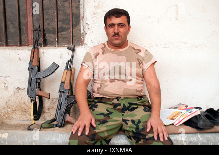 Portrait d'un soldat peshmergas kurdes posant avec sa kalachnikov à un point de contrôle le long de la route, ou Haji Omran Hamilton Road, dans le Nord de l'Iraq. Banque D'Images