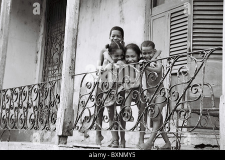 Portrait d'un groupe d'enfants sur le balcon riant et regardant l'appareil photo à Santiago de Cuba. Banque D'Images