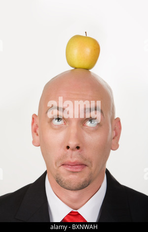 Funny businessman ayant pomme sur la tête et à le regarder Banque D'Images