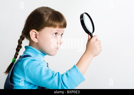 Image de fille mignonne avec lentille en part à la légère hausse par elle Banque D'Images