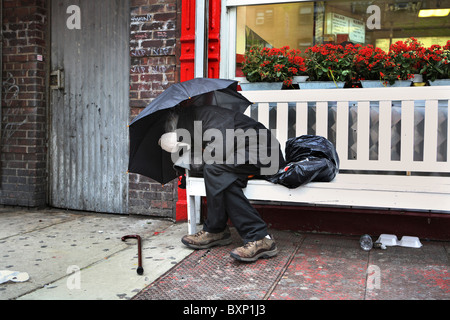 Un homme dort sur un banc, New York City, USA Banque D'Images