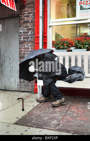 Un homme dort sur un banc, New York City, USA Banque D'Images