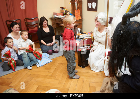 St Nicholas Angel Devil visites des enfants à la maison Banque D'Images