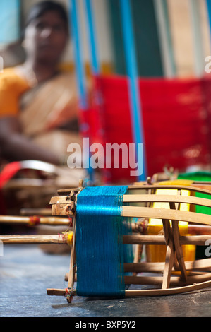 Femme indienne sari avec fil de soie de couleur du métier à tisser sur les supports. L'Andhra Pradesh, Inde Banque D'Images