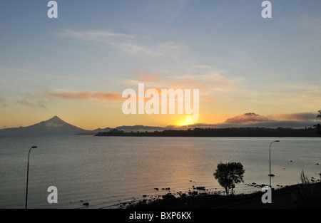 Voir l'aube, de Puerto Varas, de jaune soleil, sur les eaux du lac Llanquihue, entre les volcans Osorno et Calbuco, Chili Banque D'Images