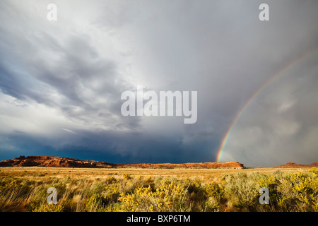 Un arc-en-ciel et nuages de tempête sur le désert du sud-est de l'Utah, près de Canyonlands National Park, USA. Banque D'Images