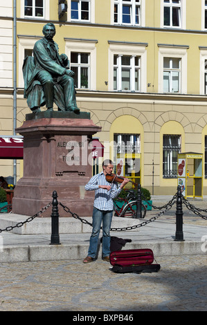 Musicien de rue jouer en face du monument à Aleksander Fredro, Wroclaw, Pologne Banque D'Images