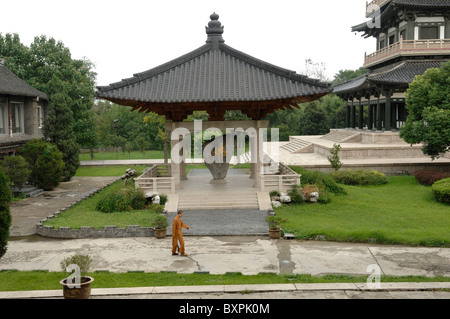 Un moine solitaire marchant dans les jardins Da Ming temple bouddhiste à Yangzhou Jiangsu Province de Chine Banque D'Images