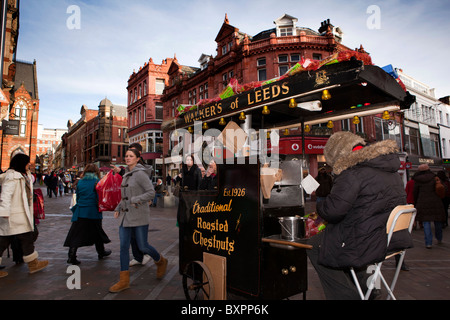 Royaume-uni, Angleterre, dans le Yorkshire, Leeds, Briggate, marcheurs de Leeds rôti traditionnel vendeur de châtaignier à Noël Banque D'Images