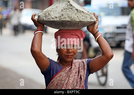 Femme portant sur la tête de ciment, Calcutta, Inde Banque D'Images