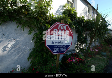 En vente un signe sur une rangée de cottages Cornish blanchis idyllique dans le village de St Teath Banque D'Images