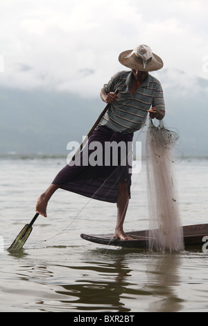 Jambe ethnie Intha pêcheur avec l'aviron sur le lac Inle dans l'État shan de nord-est, le Myanmar (Birmanie). Banque D'Images