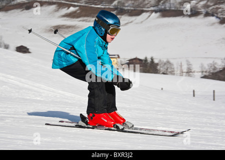Enfant portant un casque de ski de descente rapide ski pistes de ski sur la neige dans les Alpes autrichiennes. Rauris Autriche Europe. Banque D'Images
