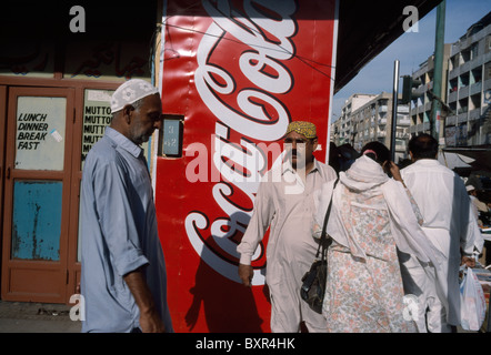 Les résidents pakistanais local devant une publicité de Coca-Cola au centre-ville de Karachi, au Pakistan. Banque D'Images