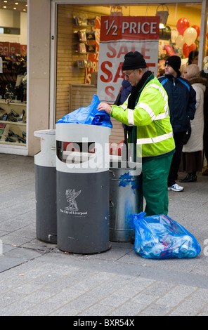 Street Cleaner vider refuser à Liverpool One, Shoppers dans les points de vente au détail de la nouvelle année, le Merseyside (Royaume-Uni) Banque D'Images