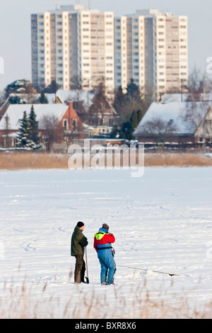Deux hommes la pêche sur un lac gelé dans la périphérie de Copenhague Banque D'Images