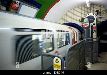 Un train de tube de quitter la station de métro Piccadilly, London, England, UK Banque D'Images