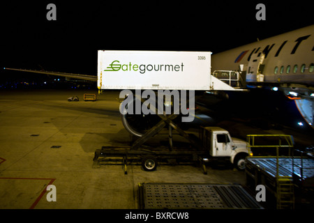 CHICAGO, ILLINOIS : Gate Gourmet des repas de chargement des camions sur un jet de United Airlines de nuit à l'aéroport international O'Hare Banque D'Images