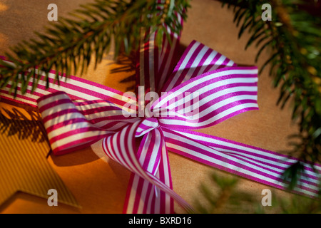 Cadeau de Noël enveloppé dans du papier brun et un ruban à rayures Banque D'Images