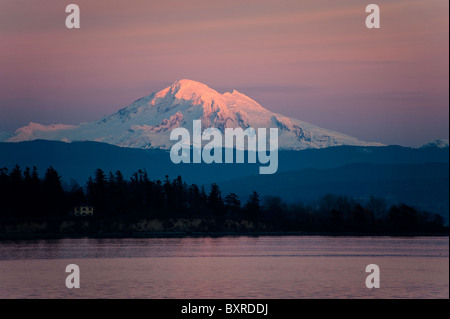 Mt. Baker, dans l'État de Washington, est inondé de alpenglow après un spectaculaire coucher de soleil dans les îles San Juan. Banque D'Images