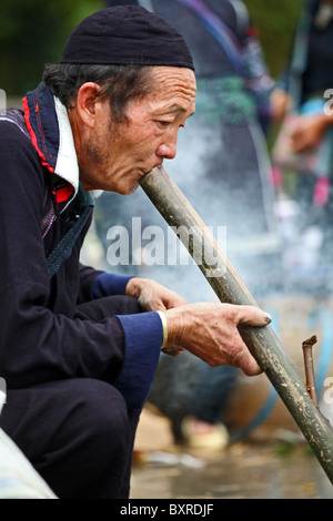 Minorité ethnique hmong noir hill tribe pipe masculin à Sapa, Vietnam du Nord Banque D'Images