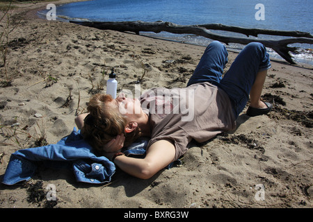 Une femme prenant une sieste sur une plage de sable fin le long de Long Island, à New York, États-Unis, le 9 octobre 2010, Katharine Andriotis Banque D'Images
