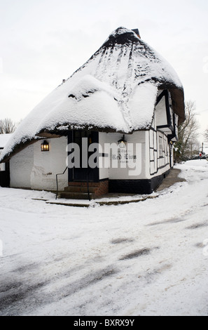 Pub traditionnel en chaume dans la neige le red lion chalton hampshire angleterre Banque D'Images